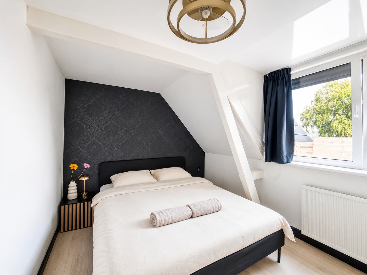 Slaapkamer met tweepersoonsbed en donker behang