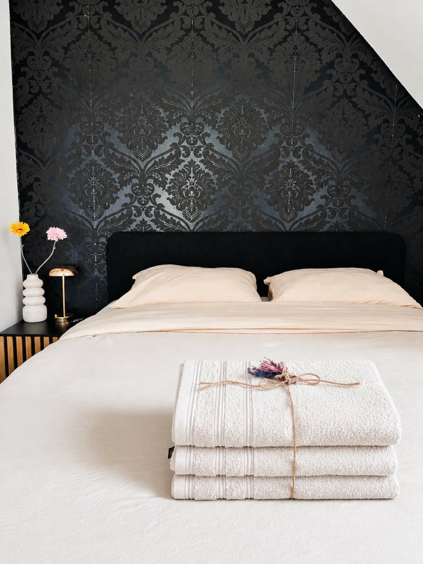 Opgemaakt tweepersoonsbed met handdoeken