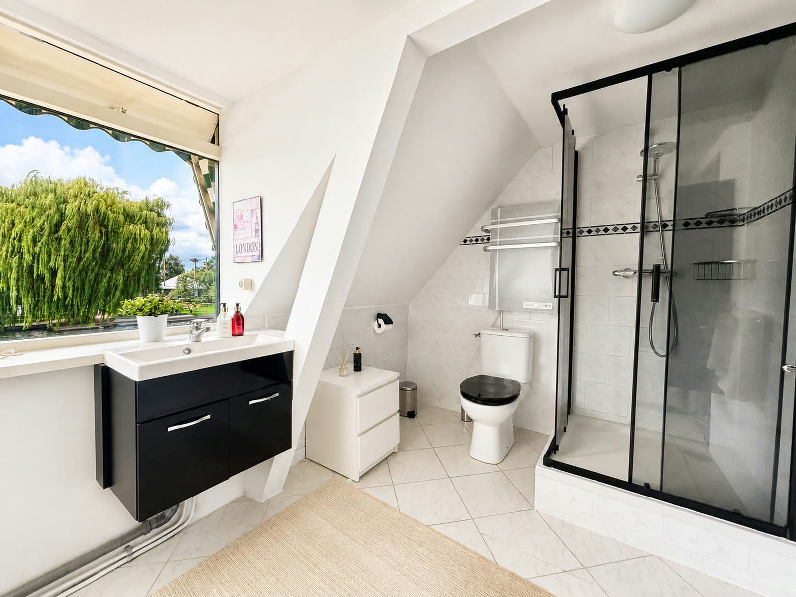 Badkamer met inloopdouche in zwart stalen frame, wastafel en toilet